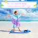 Child in mermaid scale hooded poncho towel standing on bodyboard at tropical beach, size specs shown